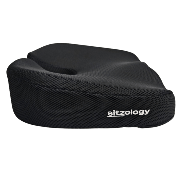 A black cushion designed for ergonomic support, featuring a textured surface and a cutout in the center for seating.